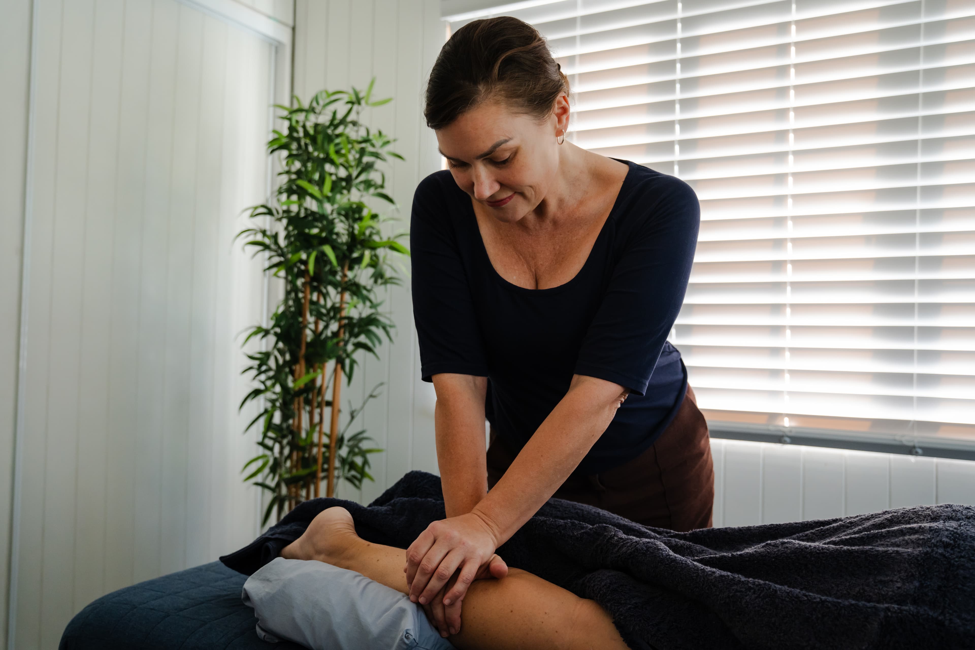 Treatment table set up for a leg, knee and foot pain session at Seabreeze Bodywork in Mermaid Waters, with bolster support positioned under the ankle for lower limb treatment